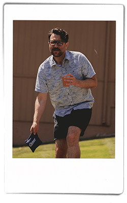 Instax picture of a man playing bean bag toss