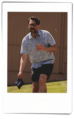 Instax picture of a man playing bean bag toss