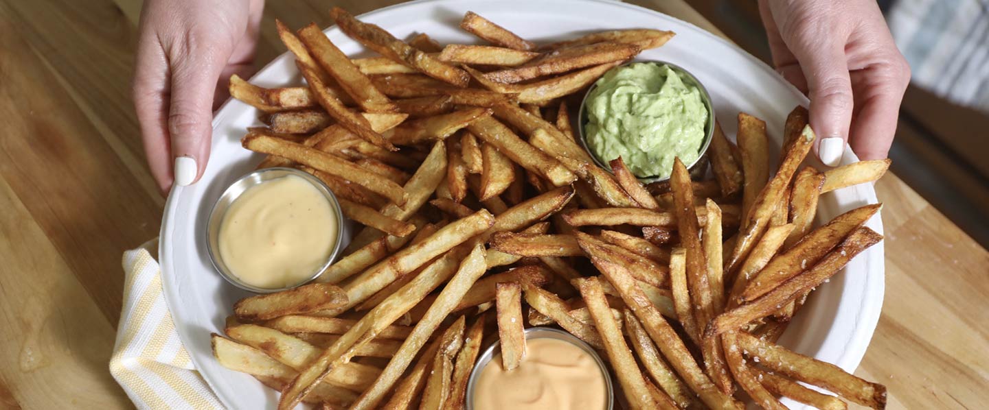 Crispy, homemade fries with sriracha mayo, avocado-cilantro sauce & beer cheese