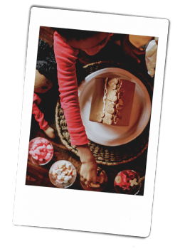 Young girls decorating a gingerbread house