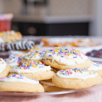 Iced sprinkle sugar cookies plated on a Chinet Crystal plate