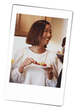 Instax picture of a woman holding a Chinet Classic plate of appetizers