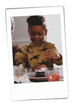 Instax of a boy decorating cupcakes