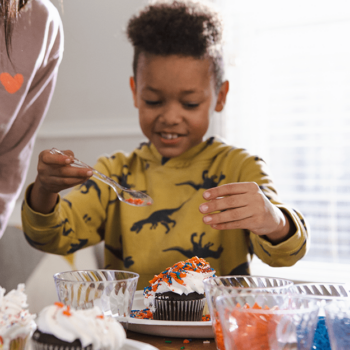 Boy decorating cupcakes