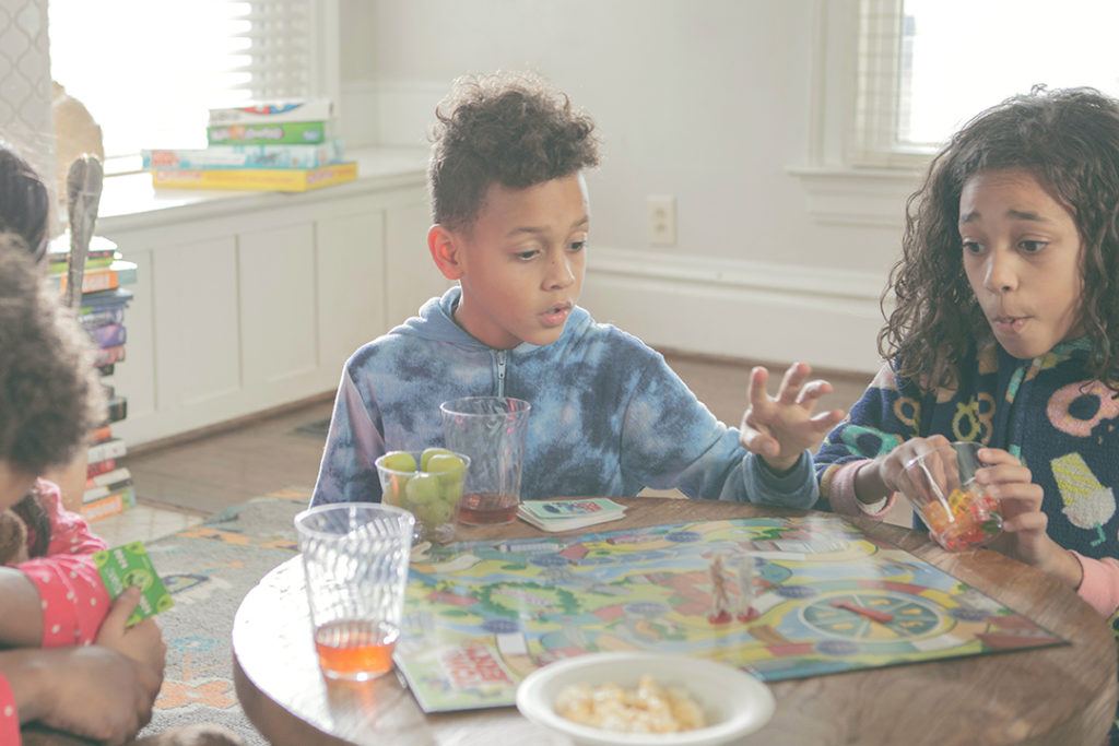 Mom and three children playing a board game