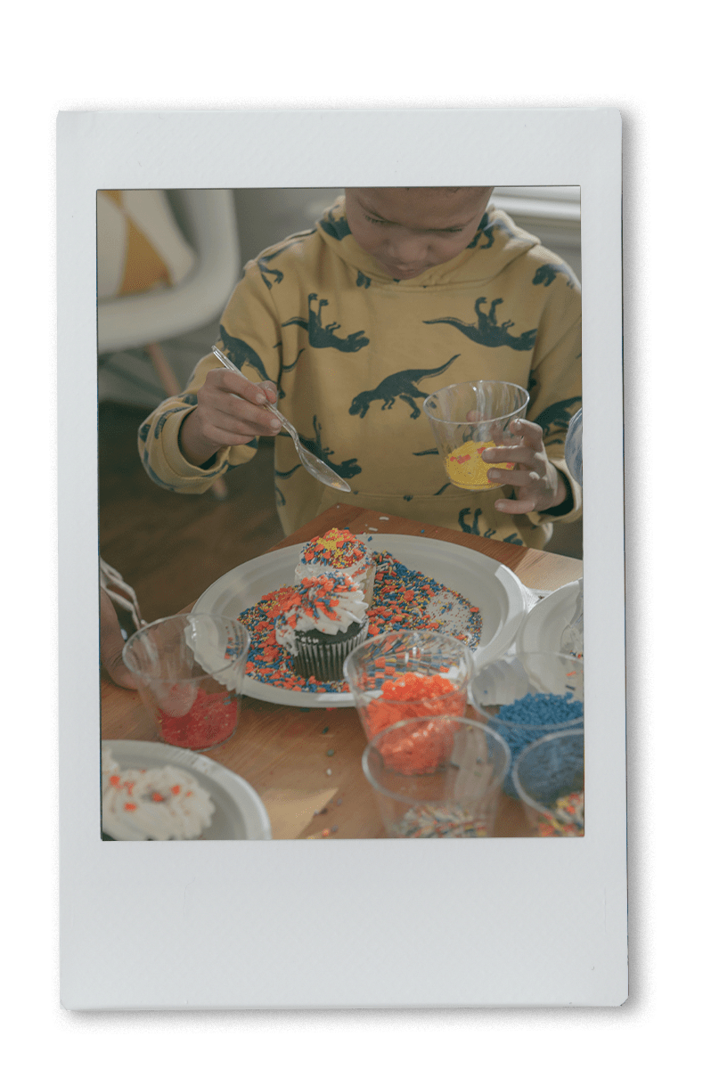 Boy decorating cupcakes on a Chinet plate