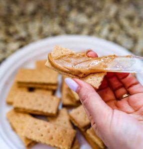 Spreading peanut butter on a graham cracker