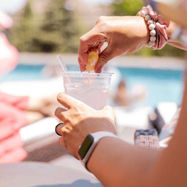 Women squeezing a lemon in a Chinet Classic Recycled Clear Cup