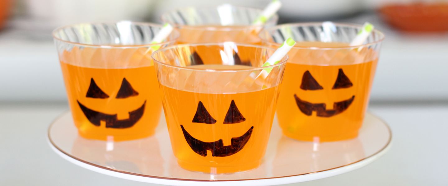 Chinet Crystal cups full of orange punch with jack o lantern faces