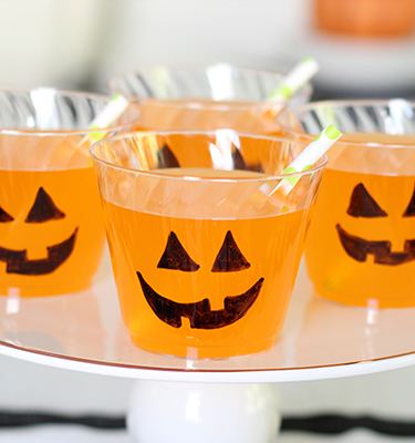 Chinet Crystal cups full of orange punch with jack o lantern faces