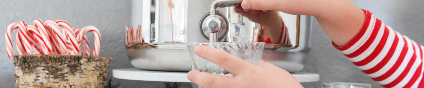 Childs hand filling up a Chinet Crystal cup