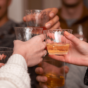 Hands holding up Chinet Crystal cups to cheers