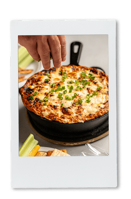 Instax picture of a BBQ chicken pizza dip in a cast iron pan