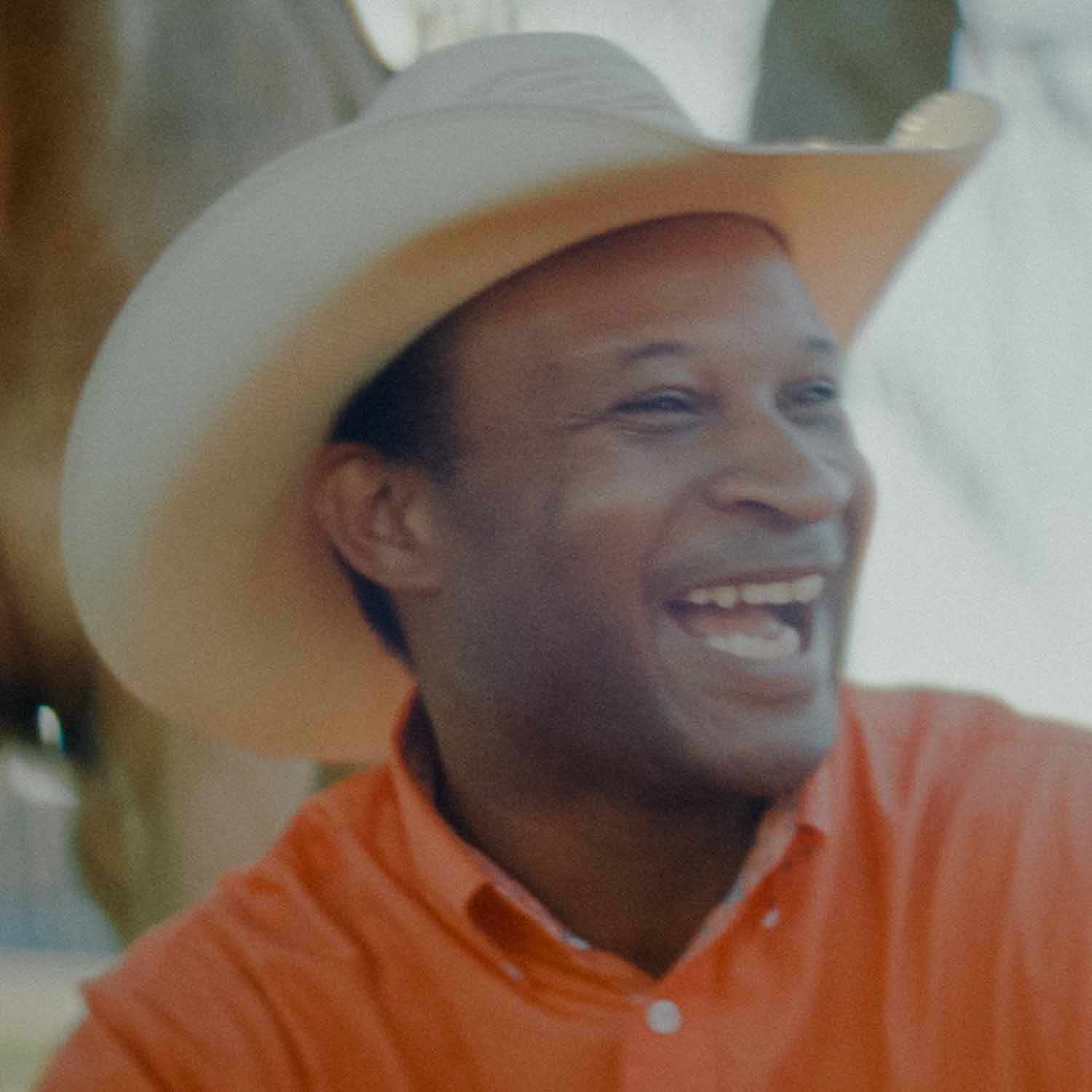A man smiling in a cowboy hat