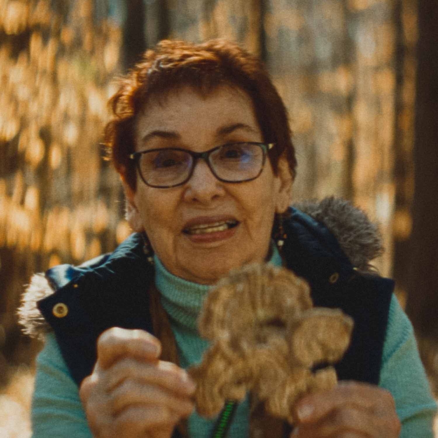 A woman holding out a freshly harvested mushroom