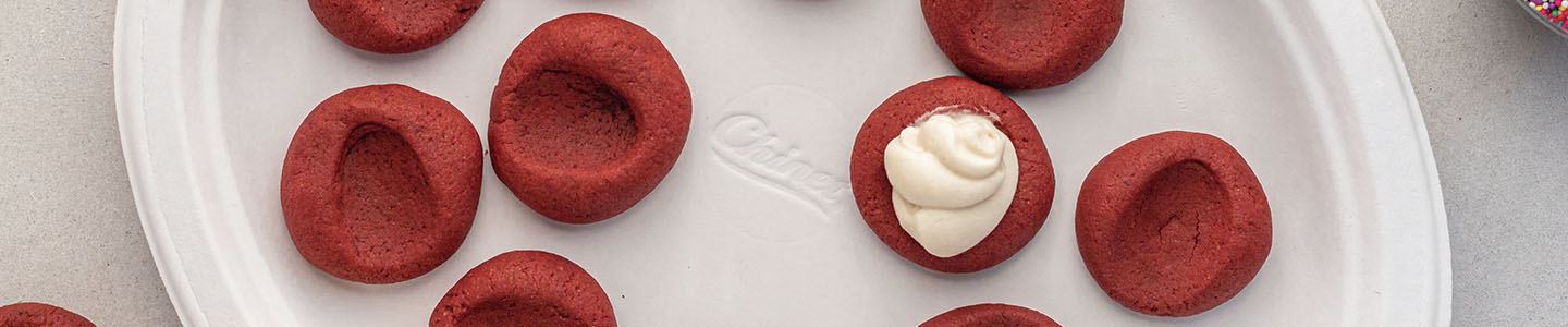 Red velvet thumbprint cookies on a Chinet Classic plate