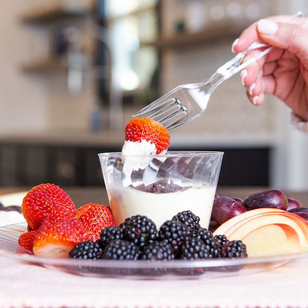 Fork dipping strawberry in frosting