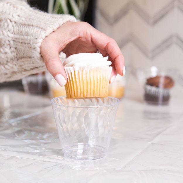 Woman putting a cupcake in a Chinet Crystal 9oz cup