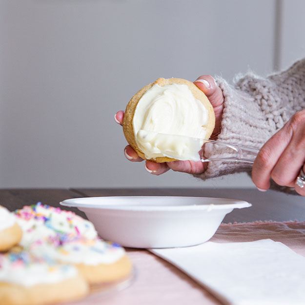 Hands icing a cookie