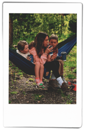 Woman and children sitting in a hammock holding Chinet Comfort® Cups