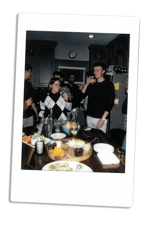 Instax picture of a group of friends eating around a kitchen counter