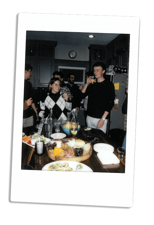 Instax picture of a group of friends eating around a kitchen counter