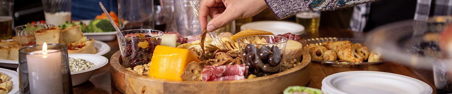 Hand dipping into a charcuterie board