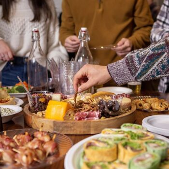 Hand dipping into a charcuterie board