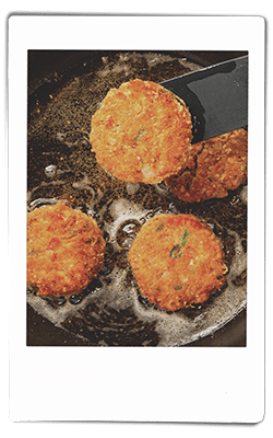 Instax picture of crawfish cakes frying in a pan