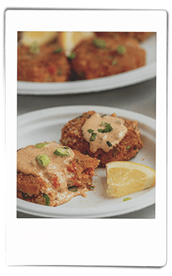 Instax picture of a crawfish cakes served on a Chinet Classic plate