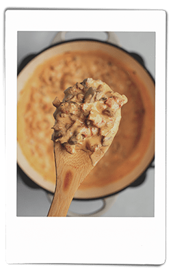 Crawfish dip mixed on a wooden spoon