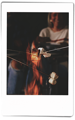 Instax picture of people roasting marshmallows on roasting poles