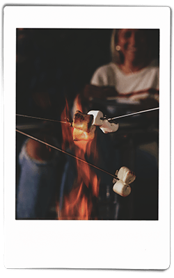 Instax picture of people roasting marshmallows on roasting poles