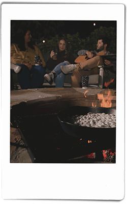 Instax of friends cooking smore's dip by the fire