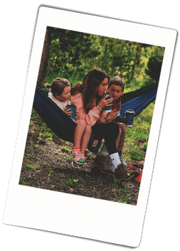 Instax picture of siblings sitting in a hammock holding Chinet Comfort cups