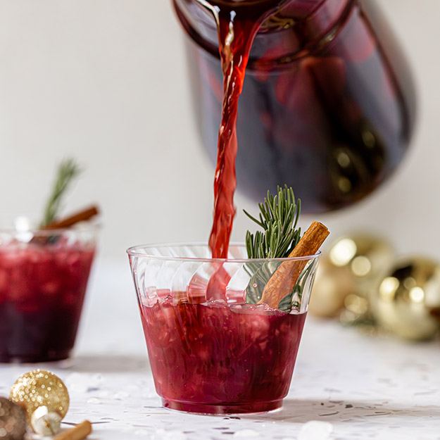 Pouring red sangria into a Chinet Crystal cup