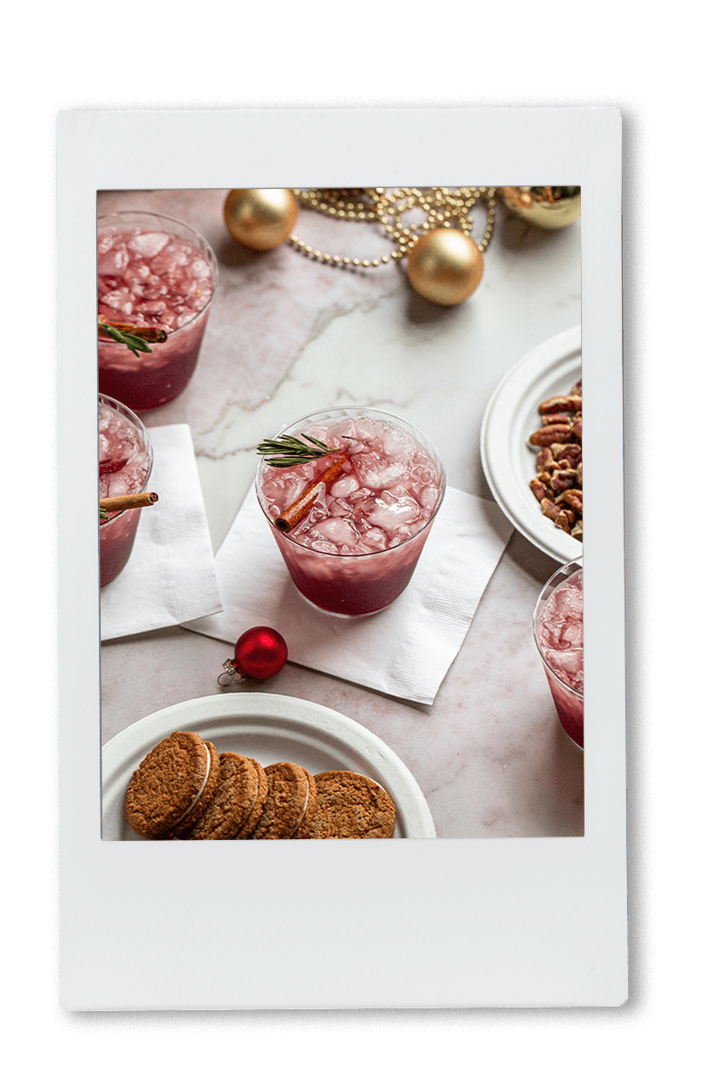 Instax picture of a table of red sangria with a cinnamon stick garnish in a Chinet Crystal cup