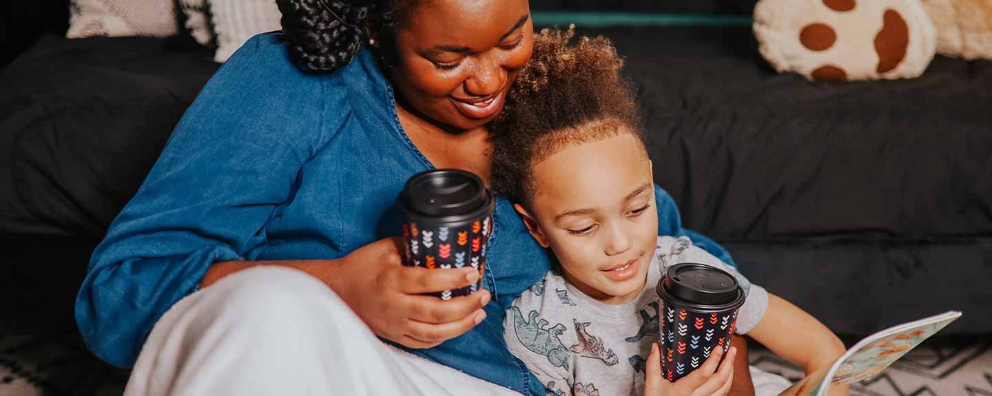 Mom and daughter sitting on a couch holding Chinet Comfort Cup