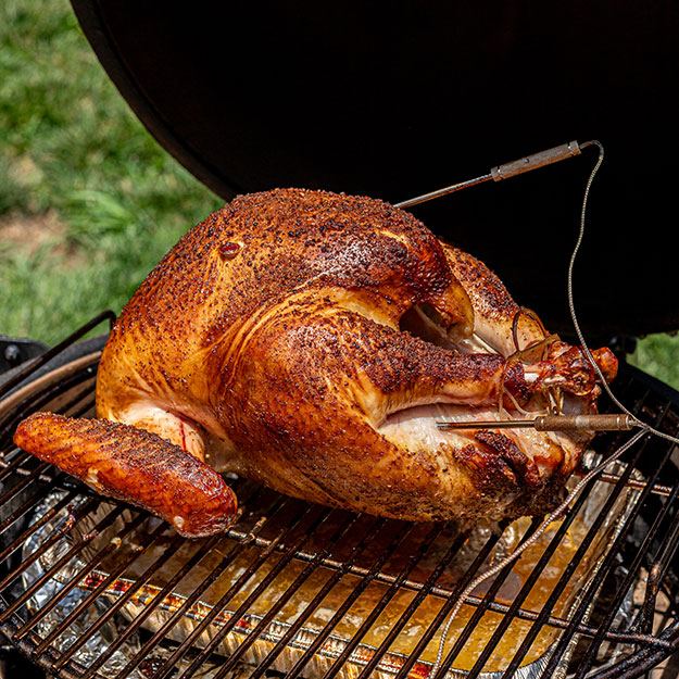 A cooked turkey in a smoker BBQ