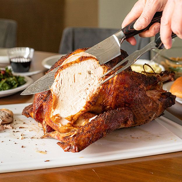 Hands carving a turkey