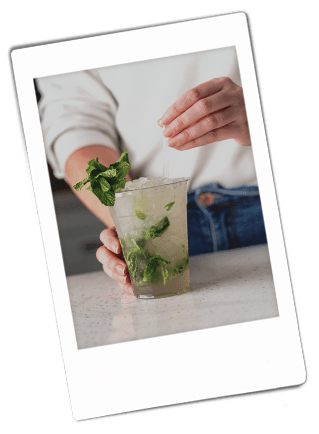 Instax picture of a woman garnishing a mojito mocktail