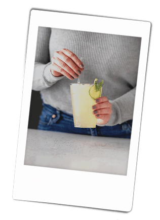 Instax picture of a women stirring a mocktail in a Chinet Classic Recycled Clear Cup