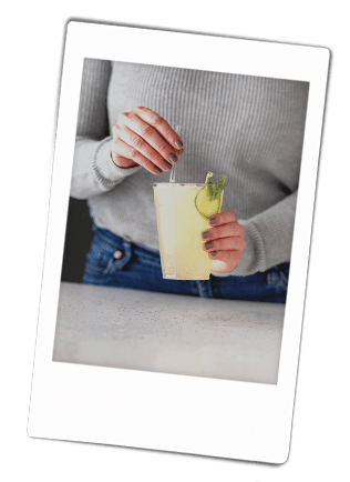 Instax picture of a women stirring a mocktail in a Chinet Classic Recycled Clear Cup