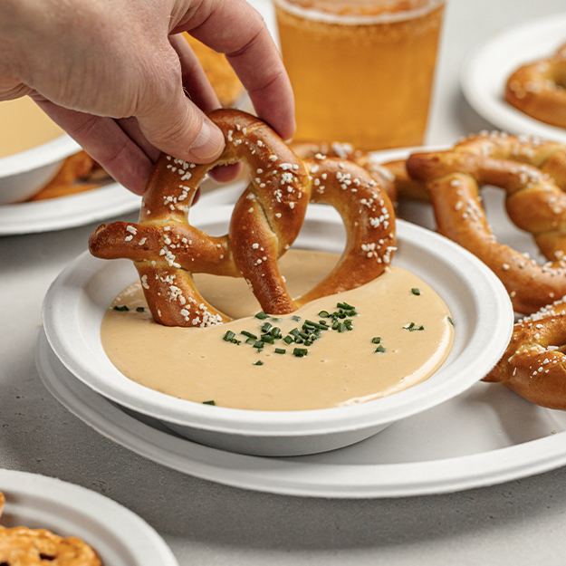 Pretzel be dipping into a bowl of beer cheese dip