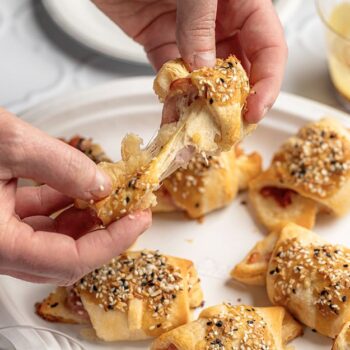 Ham and cheese crescent rolls being pulled apart on a Chinet Classic Dinner Plate