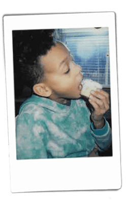 Instax picture of a boy eating a cupcake
