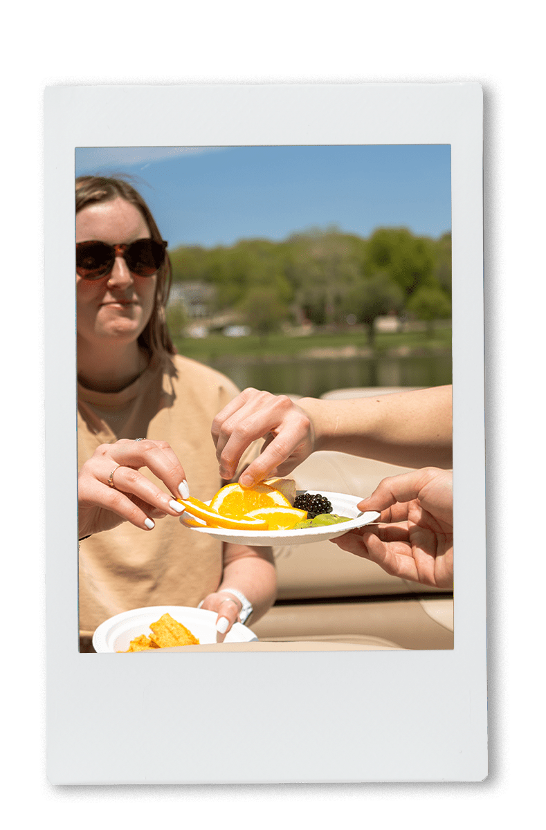 People sharing snacks on a boat on a chinet plate