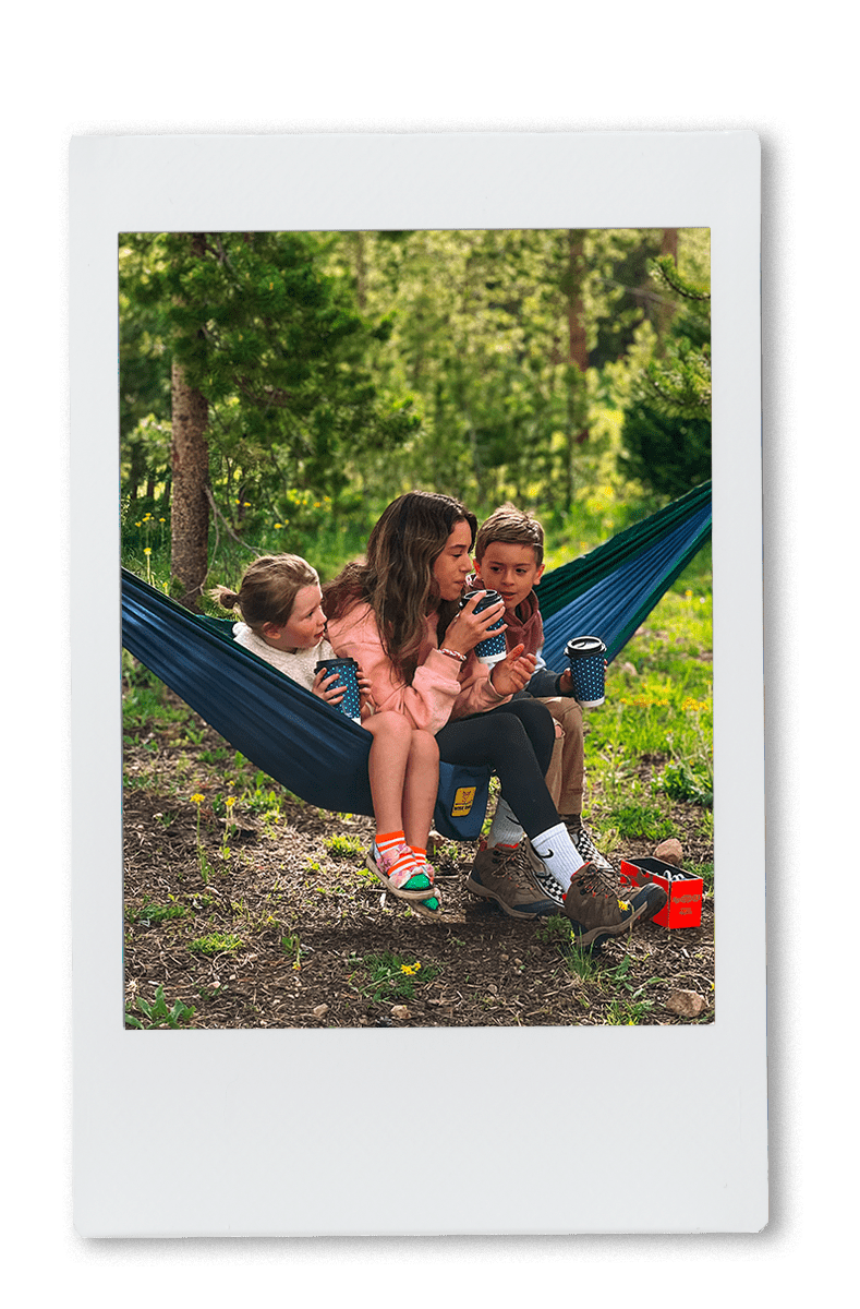 Family sitting in a hammock drinking out of chinet comfort cups