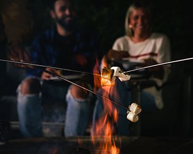 Marshmallows roasting on a stick over a campfire