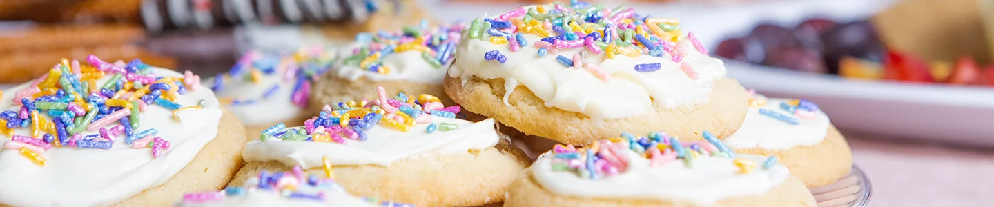 Iced sprinkle sugar cookies plated on a Chinet Crystal plate